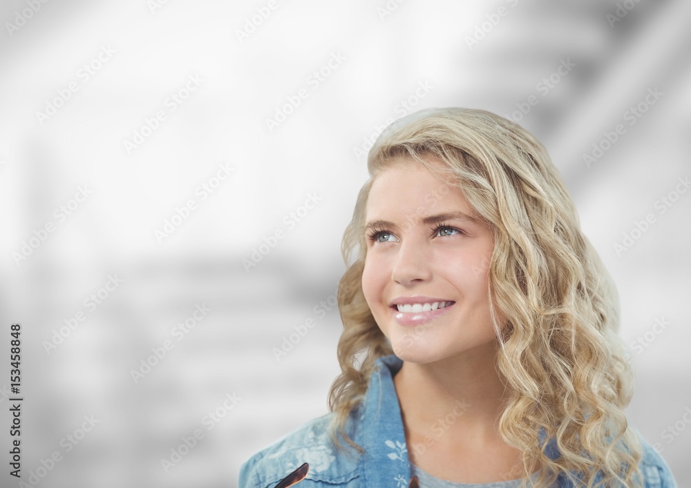 Thoughtful woman smiling against blurred background