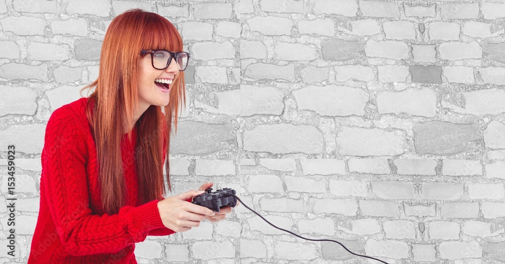 快乐的女潮人靠墙玩电子游戏