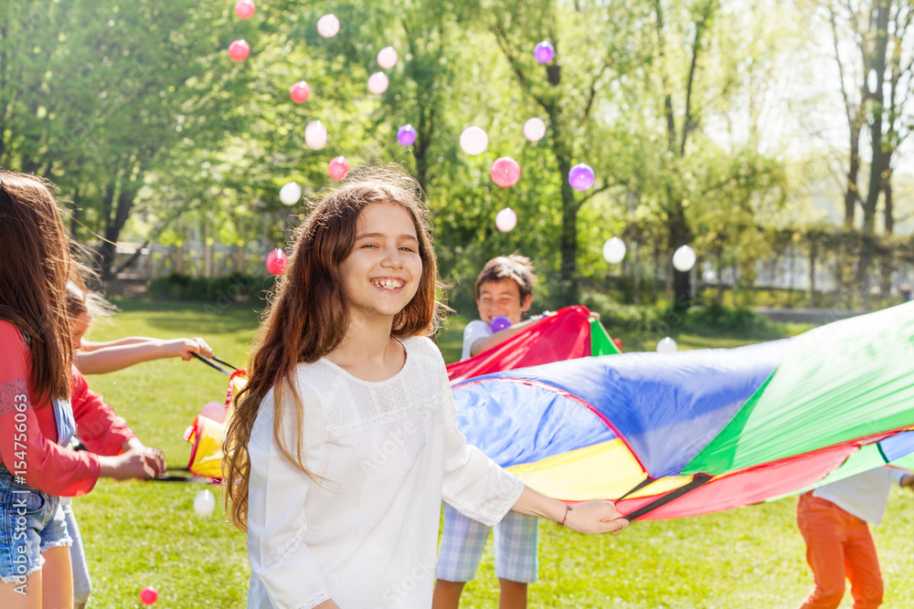 Smiling girl playing together active game outdoors