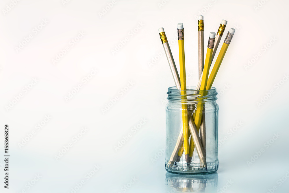 The golden yellow pencil in glass jar on white background with copy space , creative work idea or wr