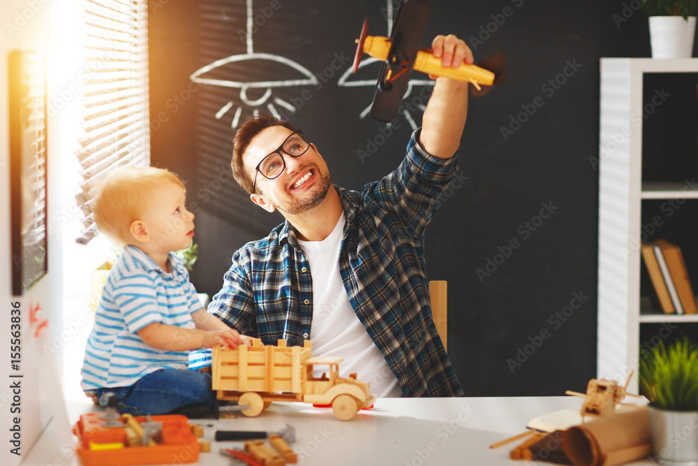 父亲和儿子蹒跚学步的孩子聚在一起用木头制作一辆汽车并玩耍