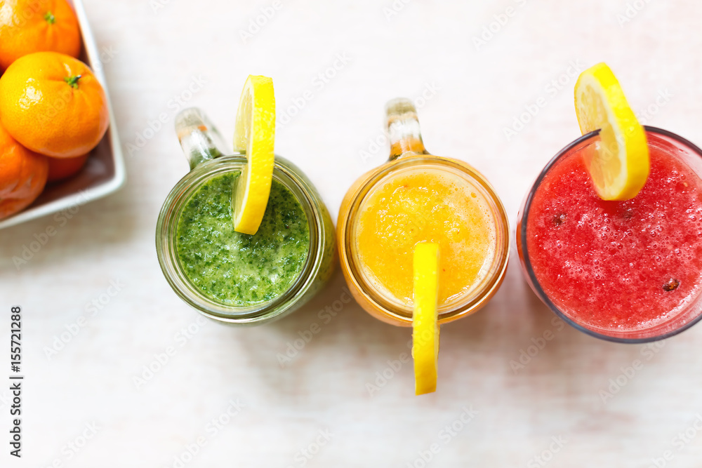 Three smoothies on a white wooden background