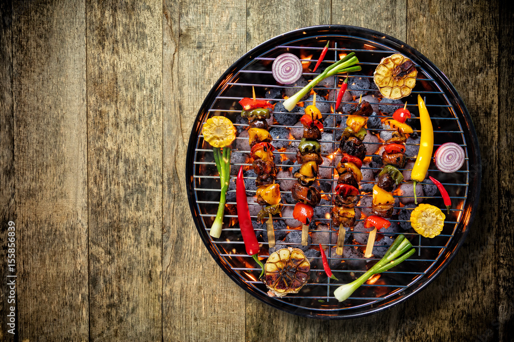 放置在木地板上的烤架上的鲜肉和蔬菜俯视图