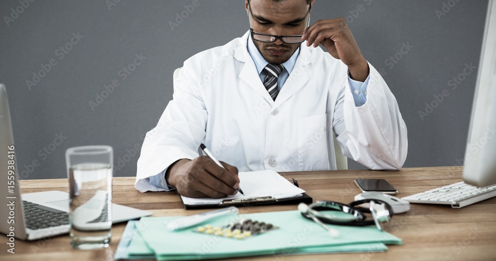 医生在办公桌剪贴板上写字的合成图像