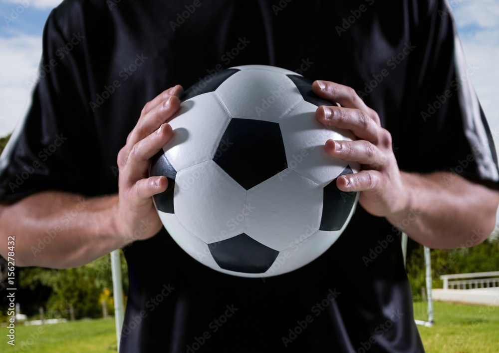 soccer player with ball in his hands, field background
