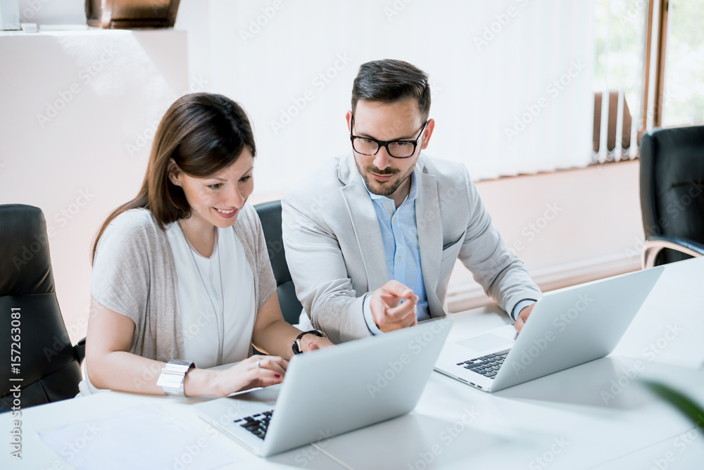 商务人士在办公桌上一起使用笔记本电脑工作