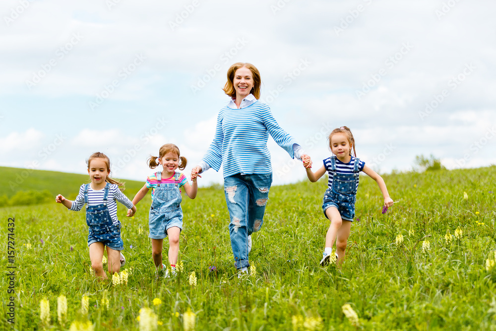 快乐的家庭母亲和孩子女儿女孩在夏天的草地上大笑和奔跑