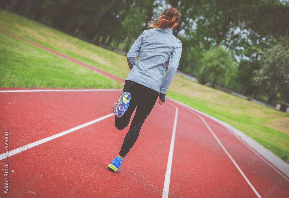 运动型女性在跑道上跑步，健康的生活方式