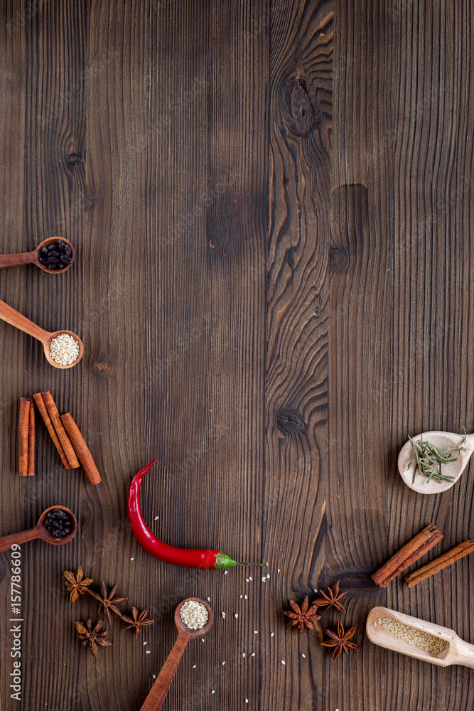 厨房木桌背景俯视模型上的干彩色香料、香草、肉桂