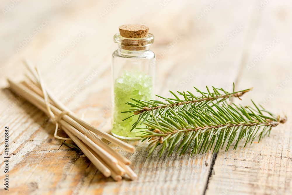 spa with organic spruce sea salt in glass bottles on wooden table background