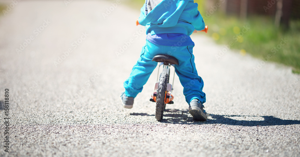 夏天公园碎石路上骑自行车的孩子
