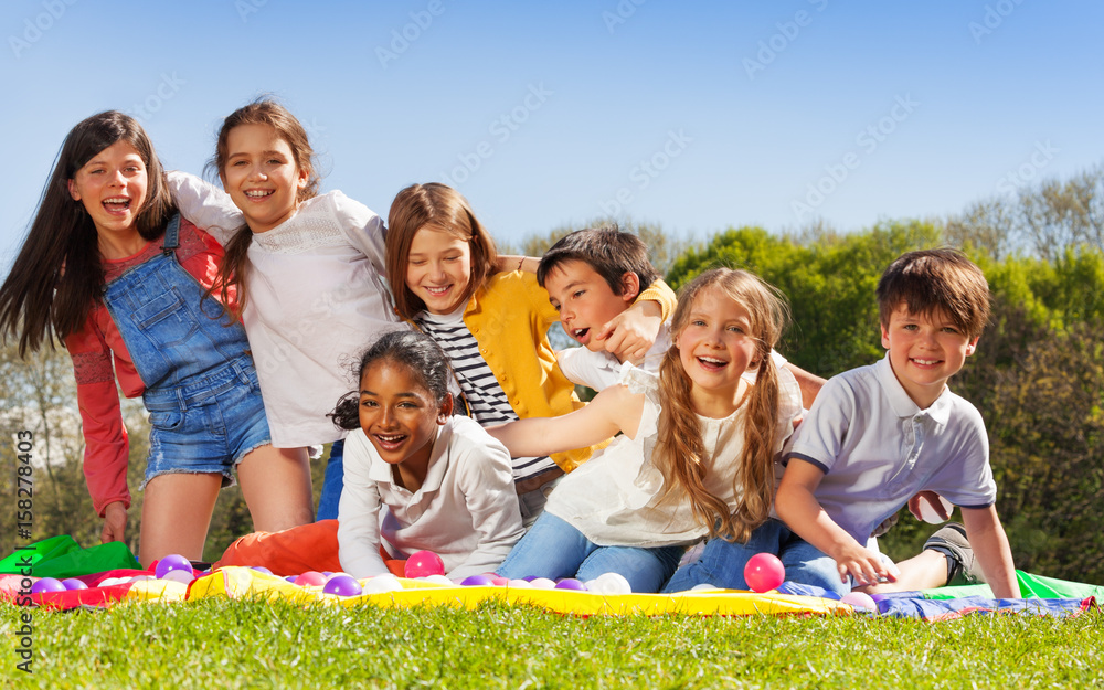 快乐的孩子们坐在公园的草坪上玩得很开心