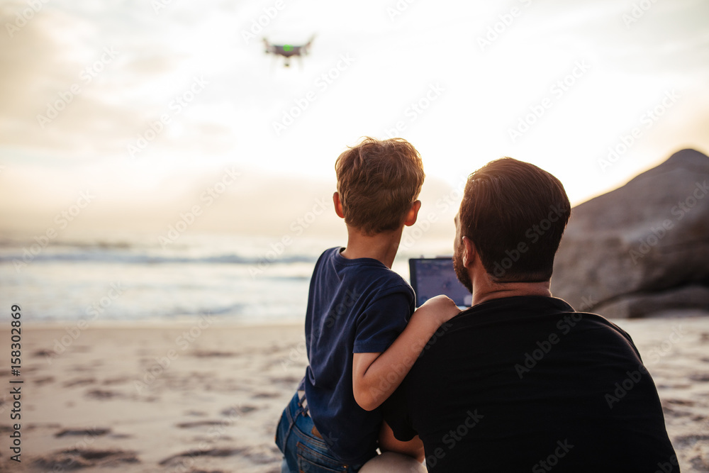 父亲和儿子在海滩上驾驶无人机