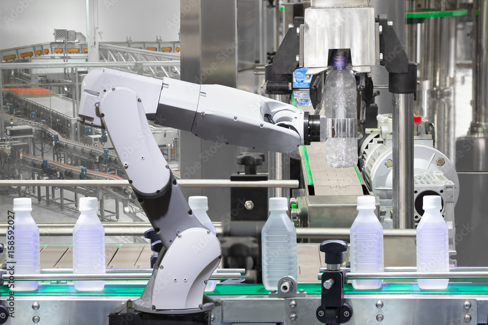 Robotic arm holding water bottles on drink production line in factory, Industry 4.0 concept
