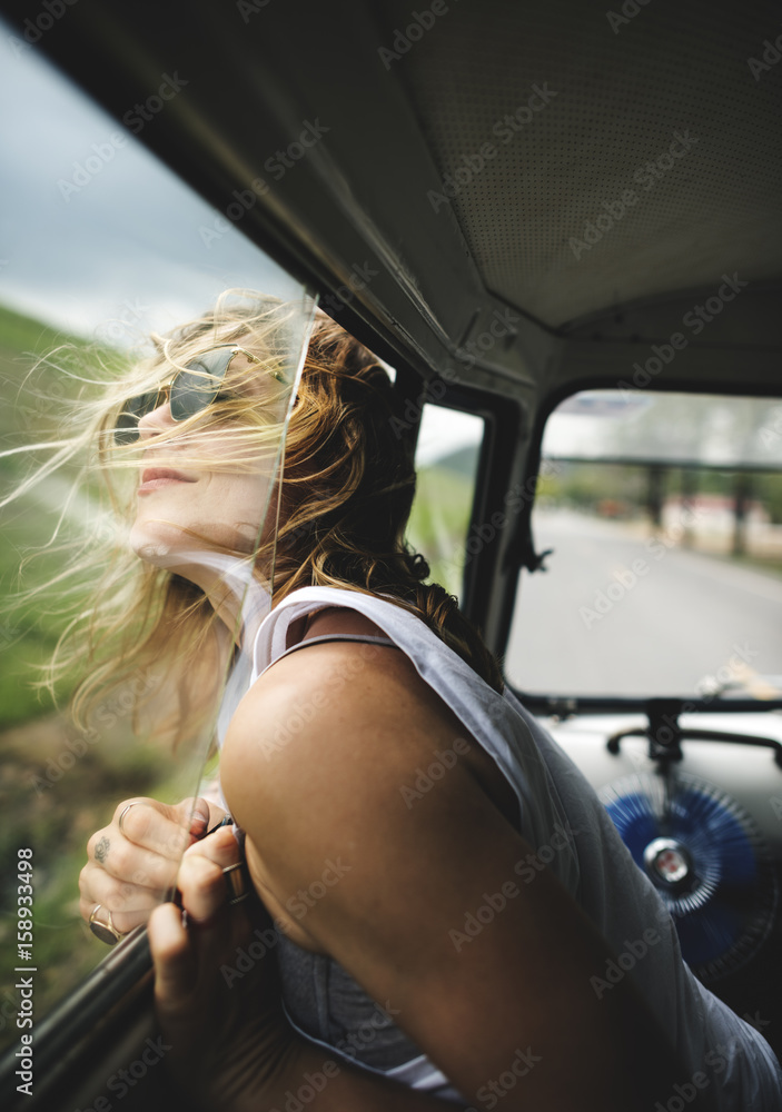 坐在车里的女人把头伸出窗外风吹头发
