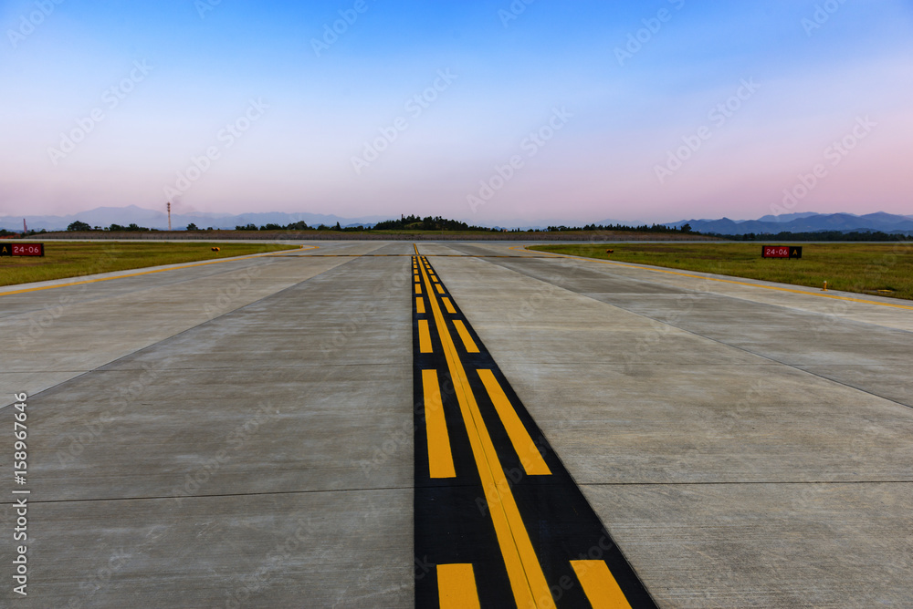 Runway, airstrip in the airport terminal with marking on blue sky with clouds background. Travel avi