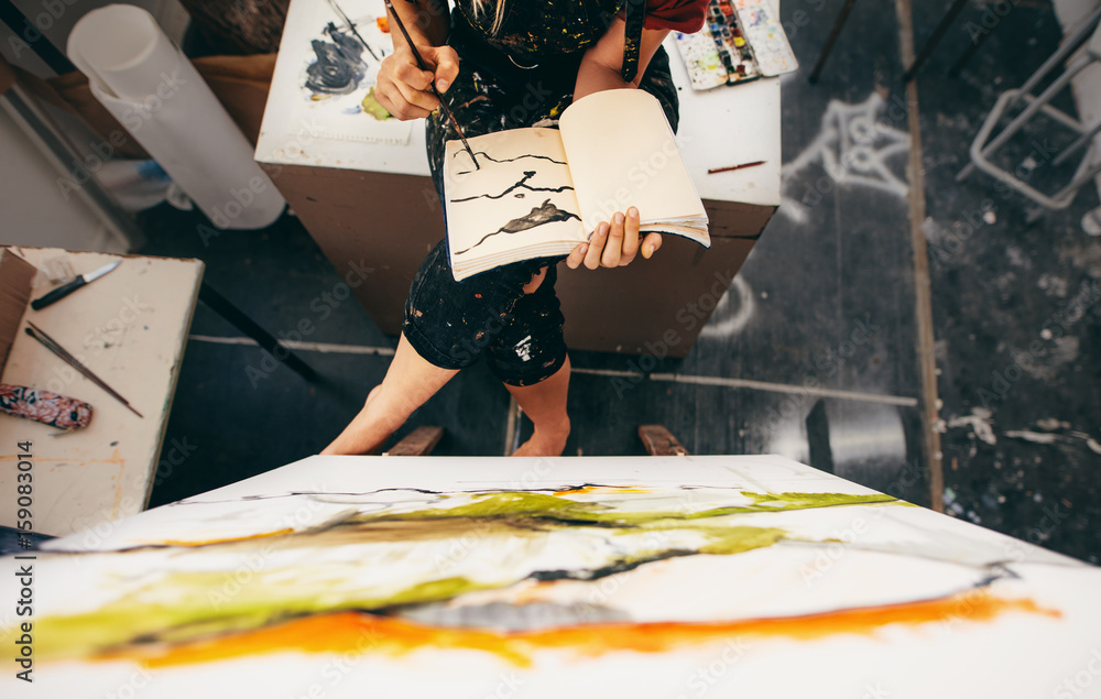 Female painter sitting in studio making a drawing