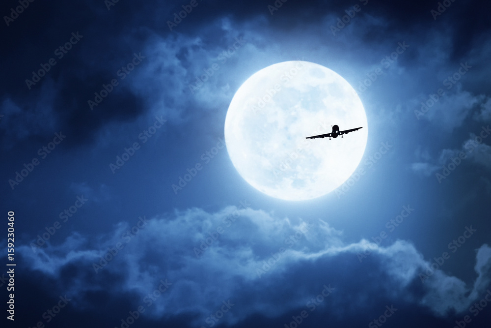 夜空中明亮的云朵和巨大、饱满的蓝月亮的戏剧性照片插图