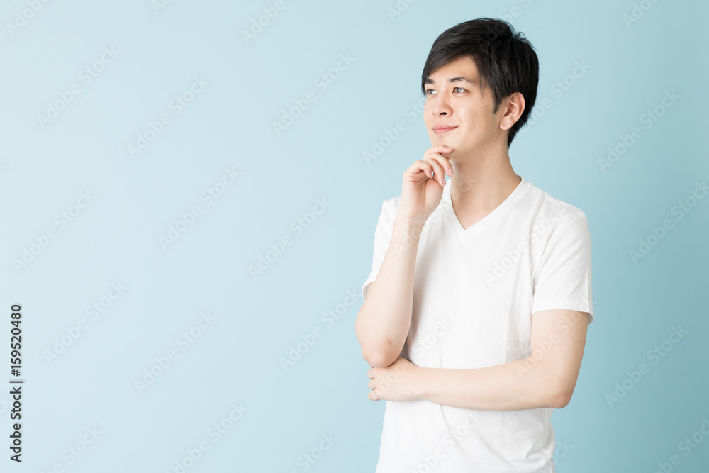 portrait of young asian man isolated on blue background