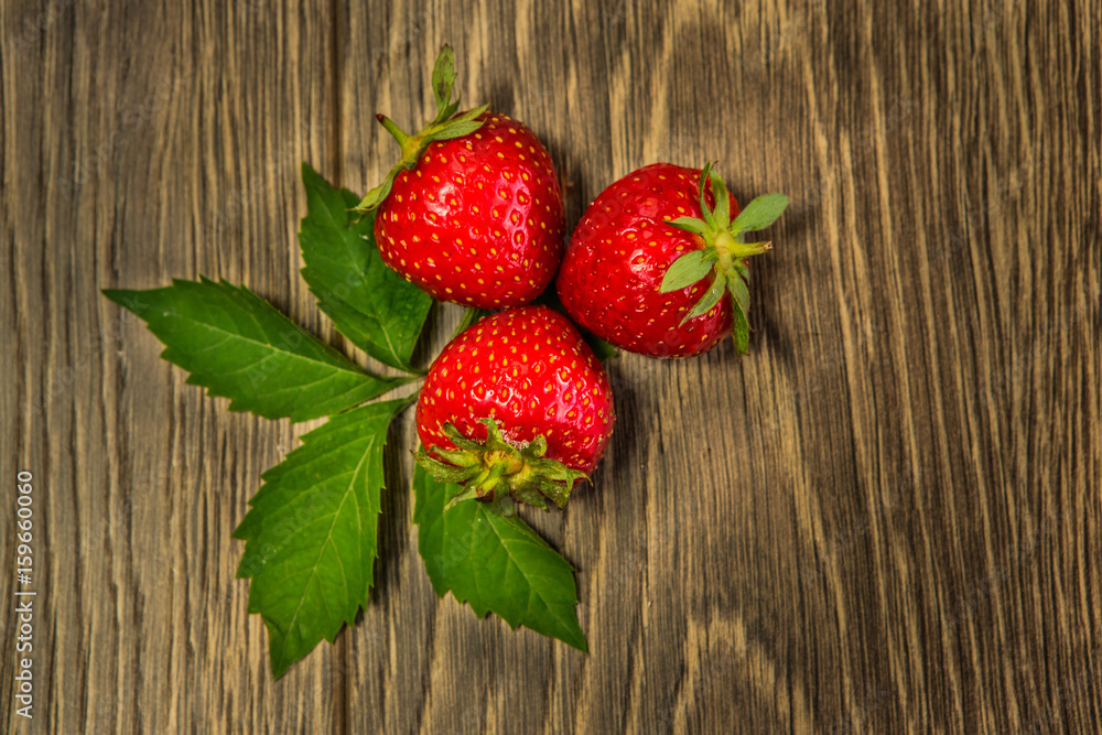在木桌上成熟的草莓。在木背景上新鲜的草莓。成熟的红色草莓。T