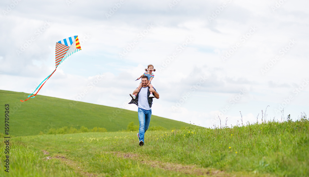幸福家庭父女在草地上放风筝奔跑