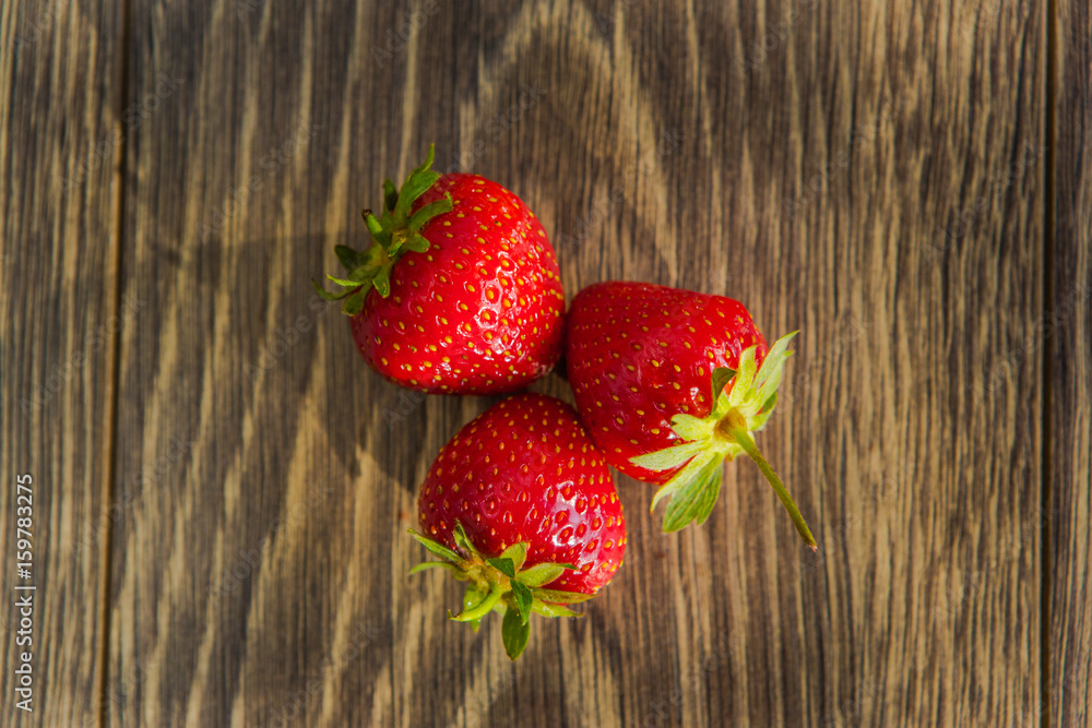 在木桌上成熟的草莓。在木背景上新鲜的草莓。成熟的红色草莓。T