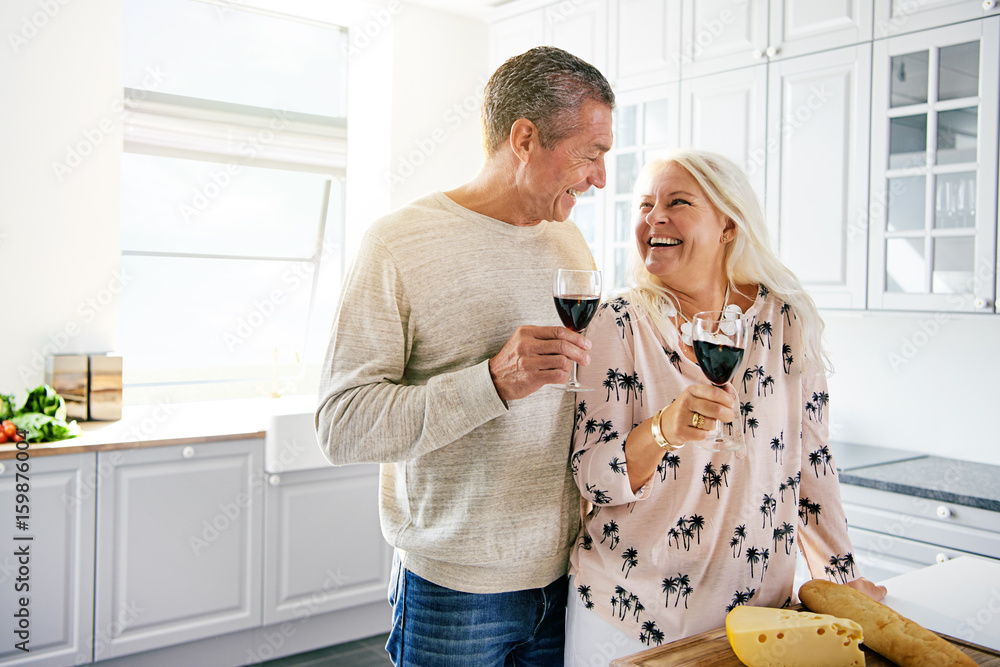 大笑的退休夫妇喝着一杯酒