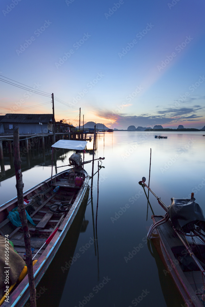 有沿海渔村的长尾船，美丽的早晨日出，俯瞰大海和群山