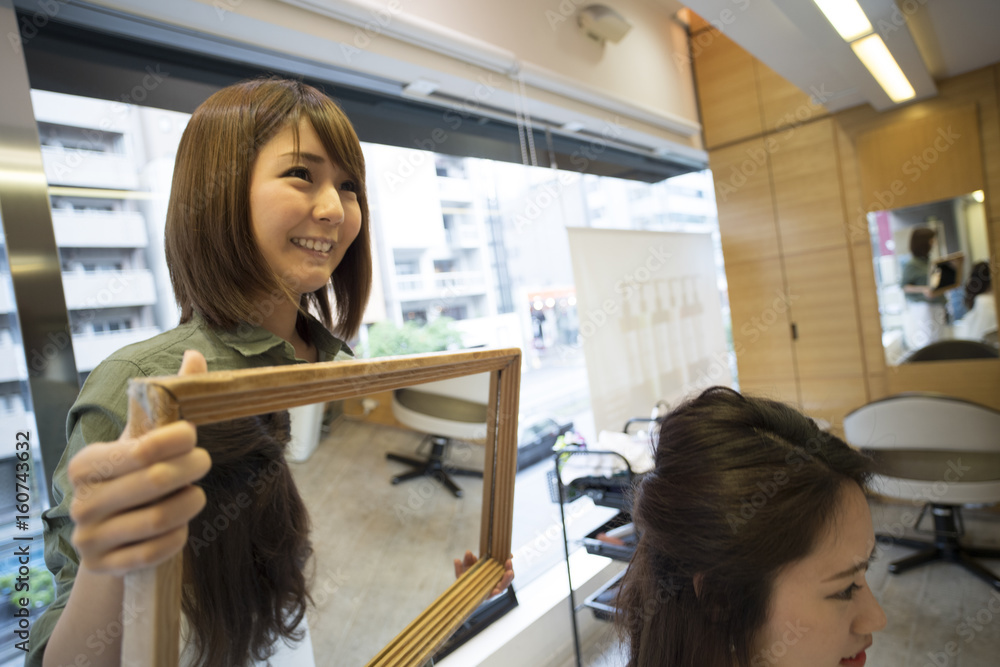 Hairdresser is confirmed finish by female customer in mirror
