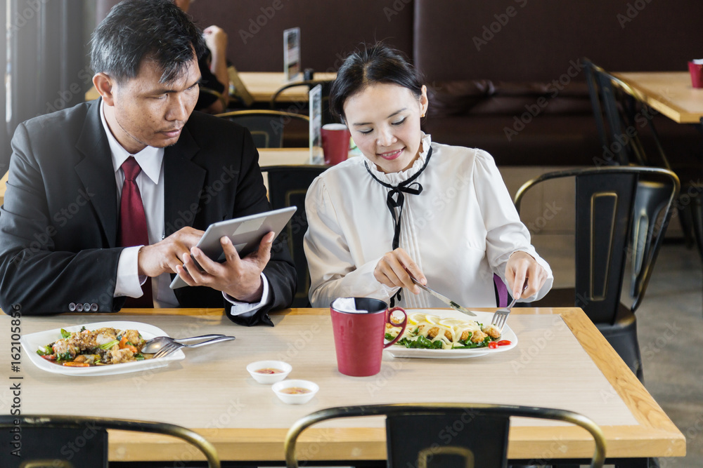 一对亚洲情侣在餐厅一起吃饭，一起开怀大笑