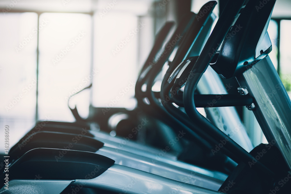 健身室背景中的近距离跑步机，具有色调和光斑效果