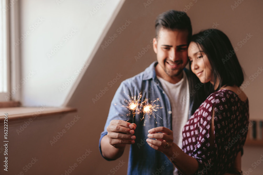 美丽的年轻情侣用焰火庆祝