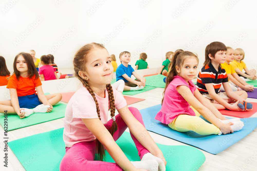 Girl doing butterfly stretch in gymnastic group