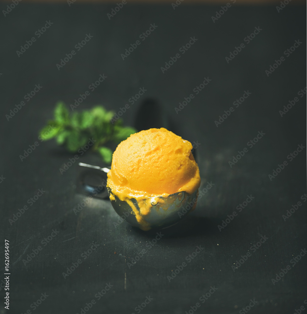 芒果冰糕冰淇淋勺装在冰淇淋勺里，黑色木质背景，复制空间，方形c