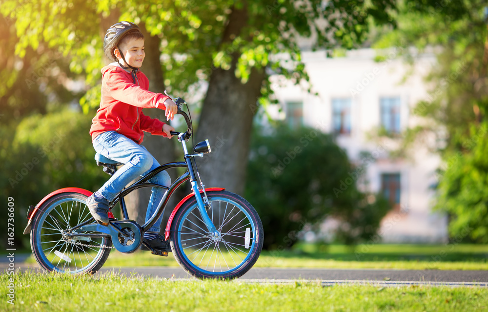 夏天孩子在柏油路上骑自行车。公园里的自行车