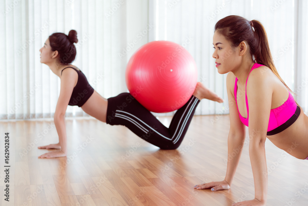 女性在健身课上用健身球锻炼身体