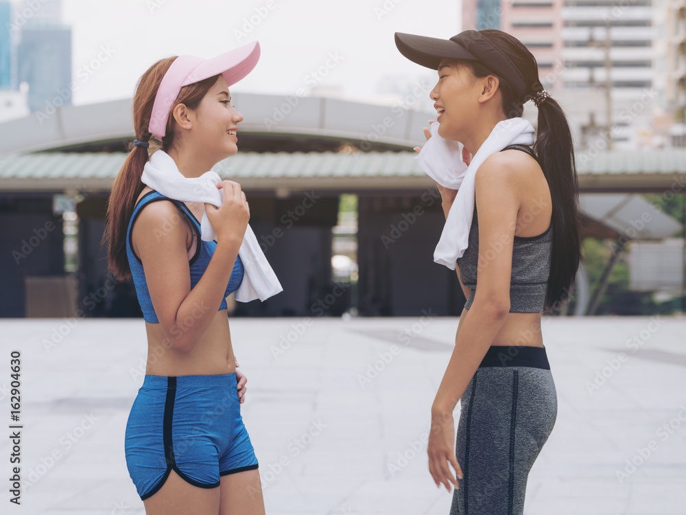 两位穿着运动服的健康女性跑步者在交谈