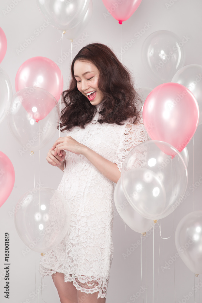 亚洲时尚美女，身穿白色连衣裙，带粉彩气球