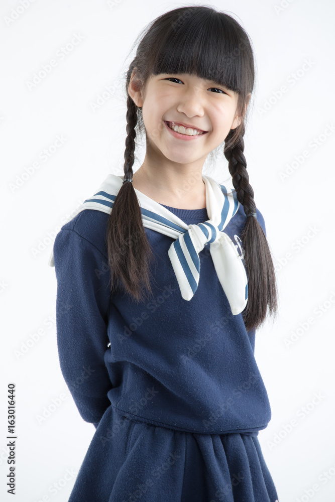 快乐的长发亚洲小孩在白色上微笑的肖像