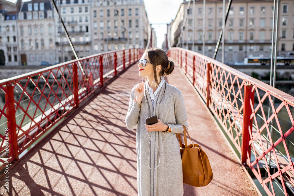 一位时尚女商人在里昂老城红桥上行走的生活方式肖像