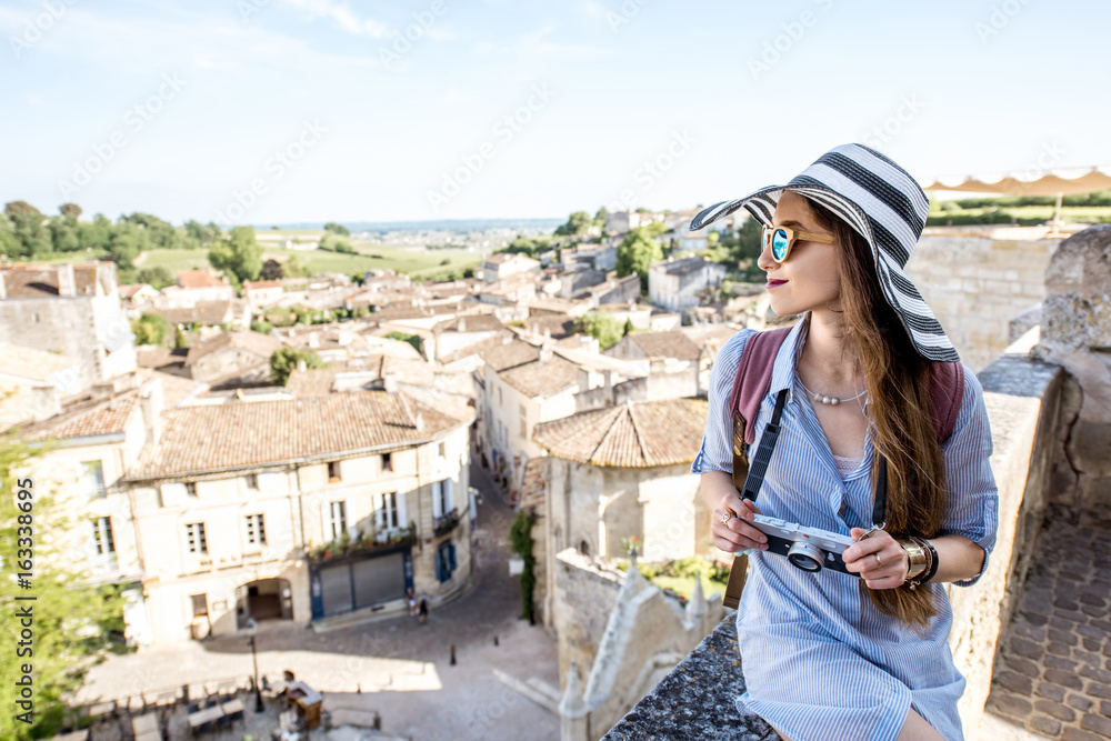 Young woman tourist enjoying beautiful cityscape view on Saint Emilion village in Bordeaux region in