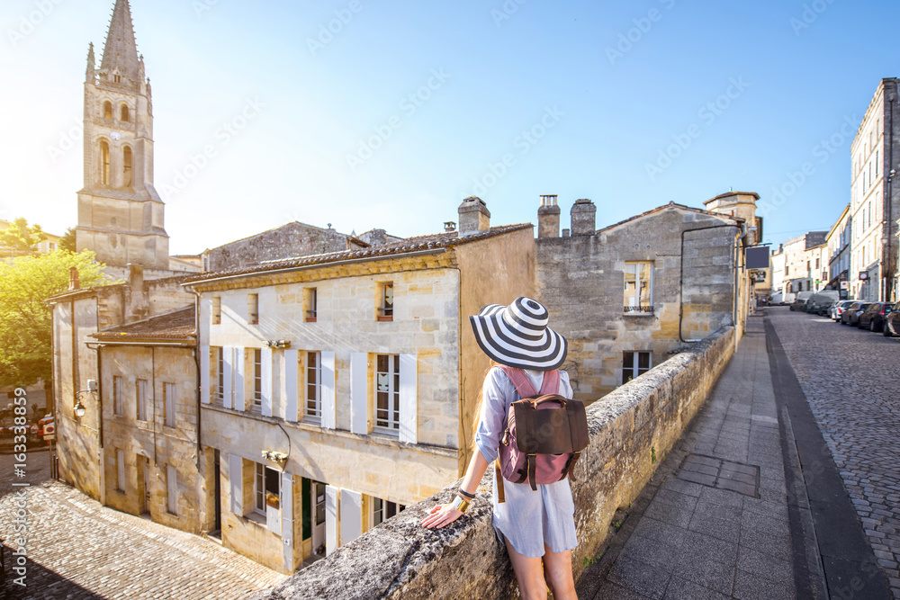 年轻的女游客走在弗拉波尔多地区著名的圣埃米利翁村的老街上