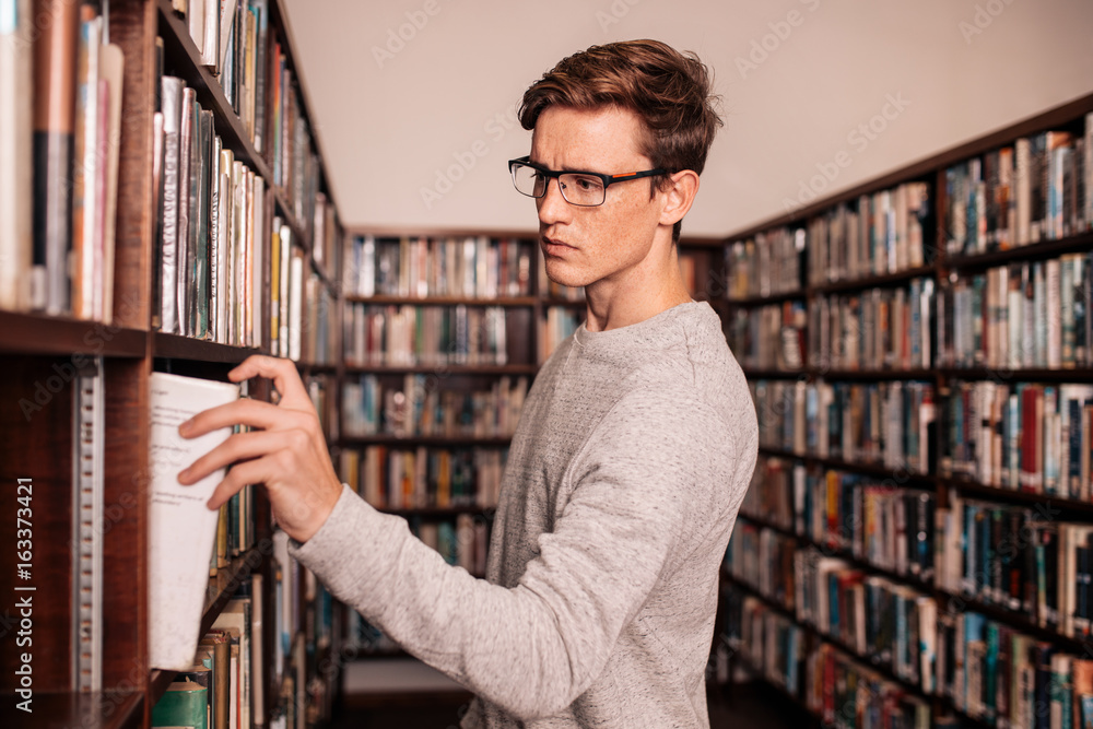 大学生从图书馆书架上取书