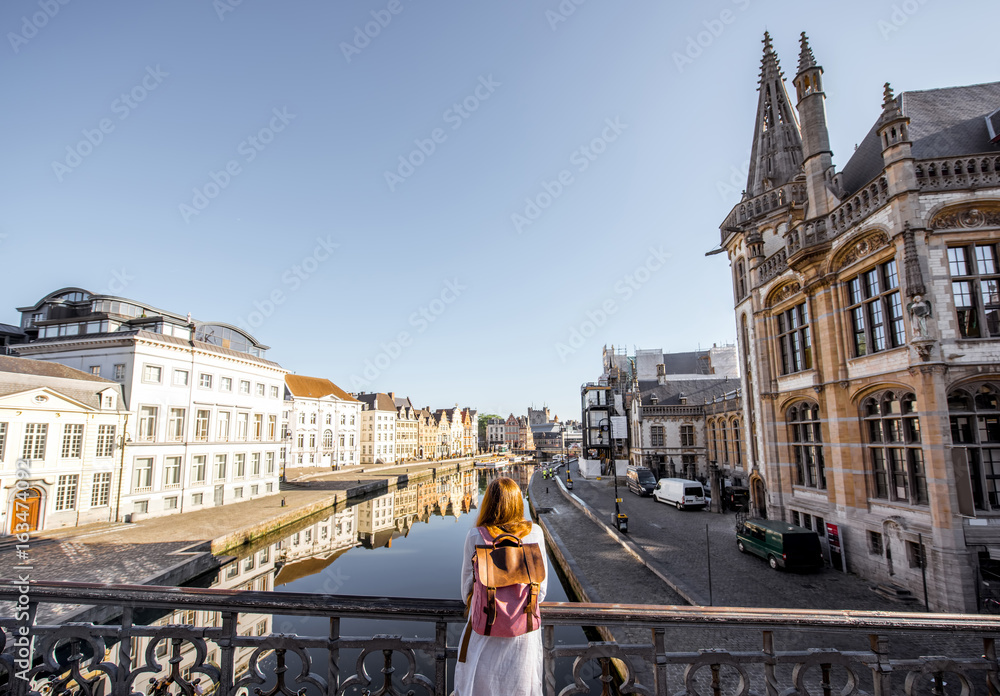 站在比利时根特市桥上欣赏水道美景的女人