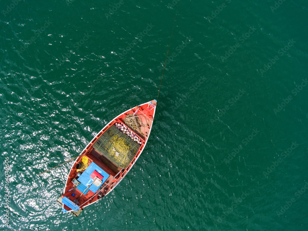 渔船漂浮在海里。晴朗的日子里，美丽明亮的蓝色海水。