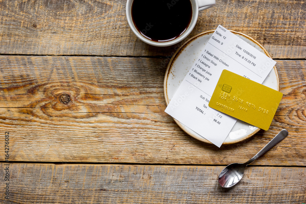 木桌背景顶视图模型上的咖啡和信用卡付款收据