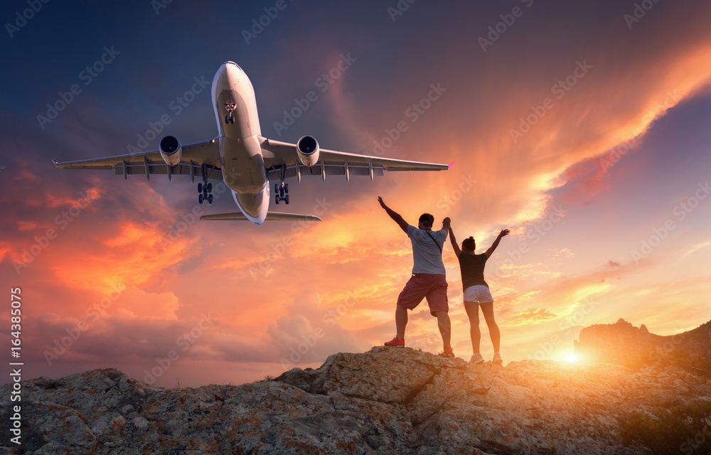 日落时，在色彩缤纷的天空下，山上的客机和快乐的人们。风景带c