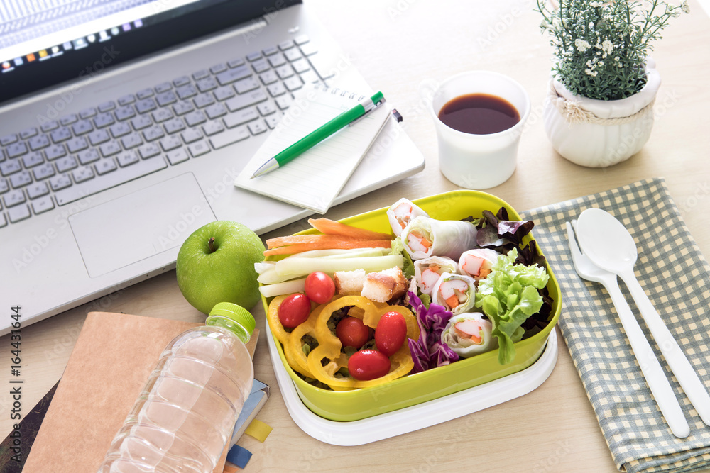 Close up green Lunch box on the work place of working desk ,Healthy eating clean food habits for die