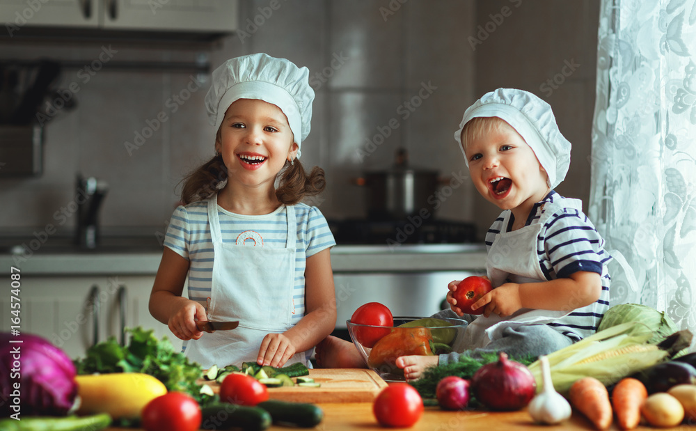 健康饮食。快乐的孩子在厨房准备蔬菜沙拉