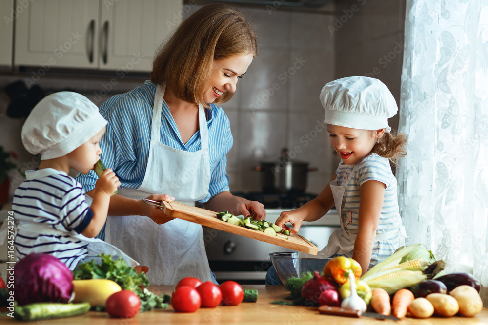 健康饮食。快乐家庭母亲和孩子准备蔬菜沙拉